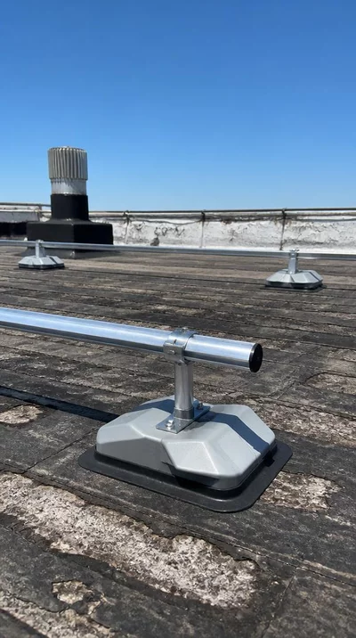 Modern non-penetrating support system on an old rooftop with visible wear and tear, showcasing innovative installation
