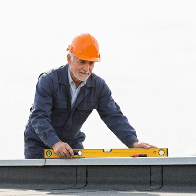Professional inspecting a flat roof for maintenance, wearing safety gear, with tools visible, clean image